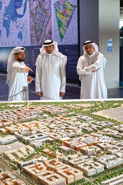<p>Visitors to Masdar Institute view a model of the city as currently planned for 50,000 residents and 40,000 commuting workers.</p>
