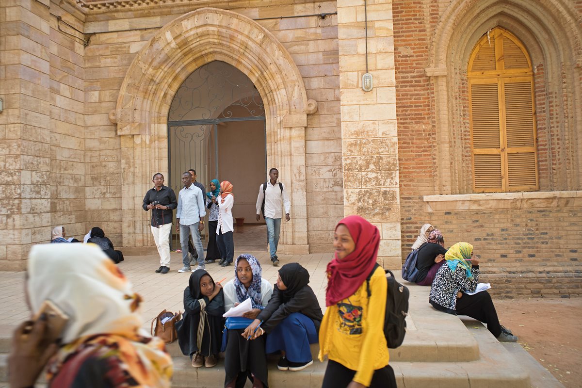 Students chat and check classwork on the steps of the main library at the University of Khartoum, founded in 1902 as Gordon Memorial College. The school is at the top of Sudan&rsquo;s educational system.