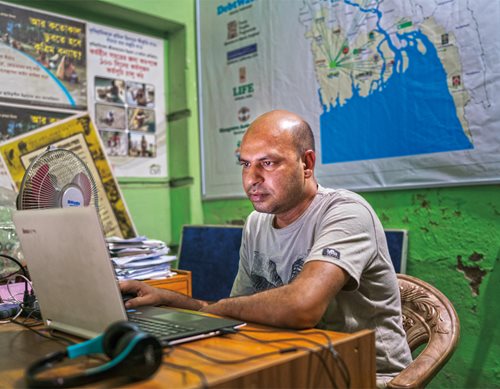 <p>With a map of the Sundarbans mounted in his office, Hasan Mehedi, <em>above,</em> chief executive of the Coastal Livelihood and Environmental Action Network (<span class="smallcaps">clean</span>), prepares an advocacy campaign for environmental conservation. The organization works to provide sustainable livelihoods of natural resource-dependent coastal communities. Teacher Abu Sattar Mostafa Kamal, <em>below,</em> helped shelter some 1,500 people at his school in Nalian on the banks of the Shibsa river after Cyclone Aila devastated the coastal region in 2009.</p>

