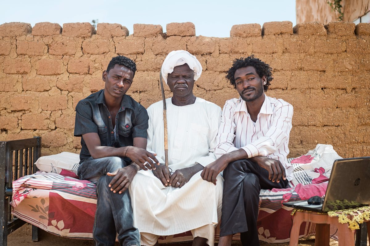 Former trail boss KhairAllah Khair al-Sayyid poses with his sons at their home in Omdurman. He drove camels from his home in central Sudan north to Egypt until a drought cost him his livestock. “My camel days are over,” he says, “and my sons do not even ride them.”