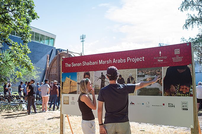 
Houstonians learn more about Marsh Arab culture through photographs near the reed structure, essentially an outdoor living museum.