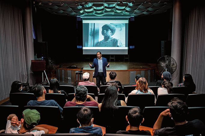 Filmmaker Darwin Yaney Mendoza hosts a screening of Kafati’s first film, Mi Amigo Ángel, in Tegucigalpa, Honduras. The film, which follows a 10-year-old shoeshine boy and was shot in the capital, kept the young audience, below right, engrossed—especially because much of the city looks the same today.