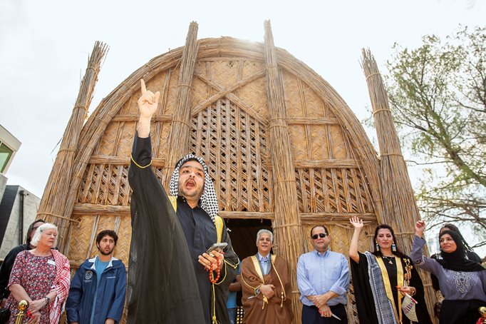 Mohannad Neamah, a Houstonian whose grandfather lived in the marshlands of southern Iraq, recites a poem at the opening of the city’s first and only mudhif. The event celebrates the effort to preserve traditional construction techniques and knowledge in danger of disappearing forever. 