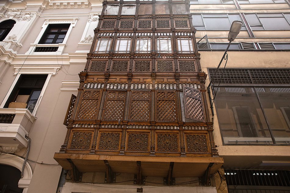 A three-story stack of balconies on Jirón Huallaga shows the lower balcony with a simple mashrabiya of wooden slats and the two upper ones with glazed windows. The frequency of earthquakes in Lima led to widespread collapses of houses with balconies, and after two particularly devastating quakes, in 1687 and 1746, colonial authorities tried to restrict homes to a single story, but they were ignored.