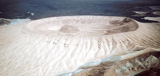 The ash crater of Jabal Bayda' ("White Mountain") contrasts so starkly with the surrounding landscape that from a distance it has been mistaken for a snow-capped peak. It has a smaller but taller neighbor, Jabal Abyad (not shown), that is also bright white. 