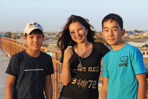 <p>Kazakh translator Dinara Kassymova poses in Aral with two boys. In 2014, British rock band Pink Floyd hired local boys for &ldquo;Louder than Words,&rdquo; a music video that looked at Aral through the eyes of youth.</p>
