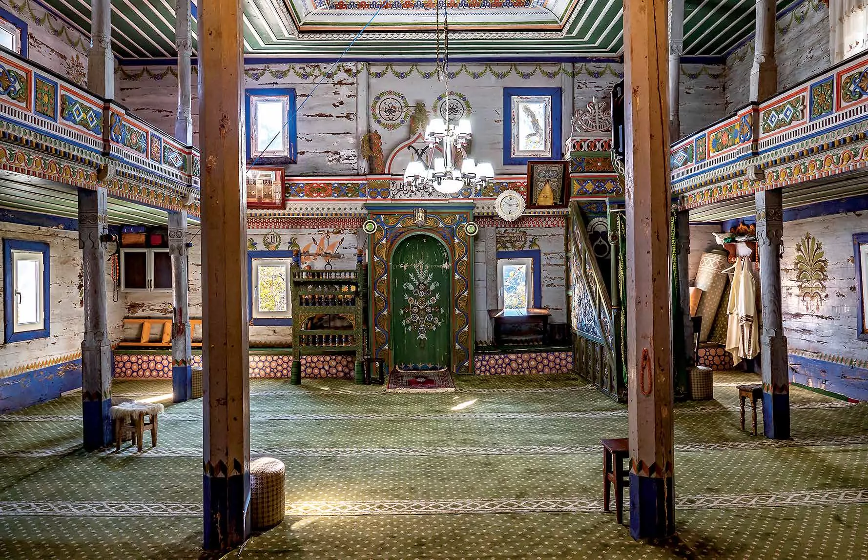 Beghleti mosque's stunning interior woodwork and colorful ornamentation stand in sharp contrast to the corrugated- metal exterior of it and other wooden mosques in the region.