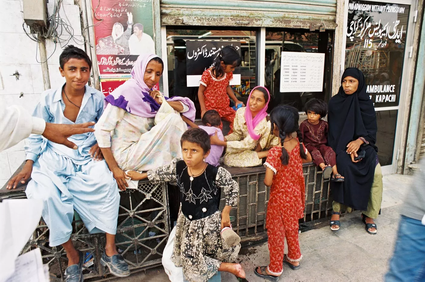 A woman abandoned by her husband waits with her children outside an Edhi center. She will ask the foundation's help in securing alimony.