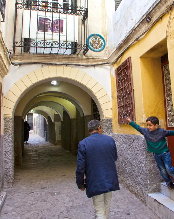 <p>The Legation&rsquo;s circular, eagle-emblazoned crest appears above an archway along one of the madinah&rsquo;s narrow streets that surround&mdash;and, here, runs underneath&mdash;<span class="smallcaps">talim</span>.&nbsp;</p>
