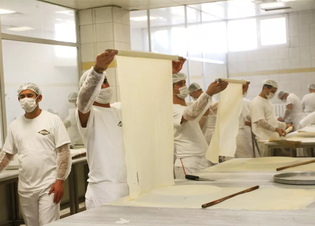 At Koçak Baklava as in the city's many other baklava kitchens, chefs roll filo dough so thin you can read a newspaper through it. This is craftsmanship, says Burhan Çaǧdaş. "The chef who makes and rolls out the dough cannot talk. He cannot think about anything other than baklava. He must be fit. He is only allowed to roll out the dough until the age of 35. Baklava chefs are like football players!&rdquo;