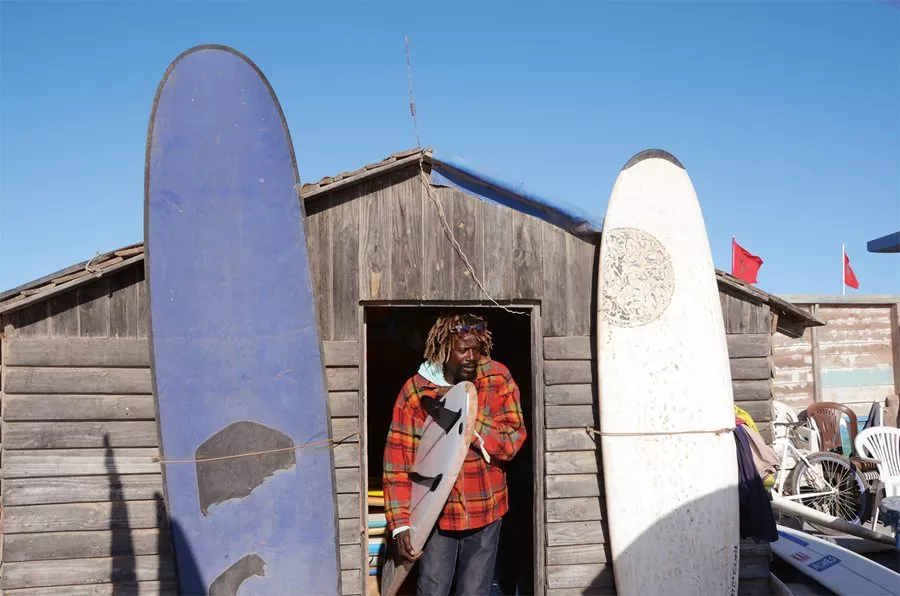 <p>Surfer Lasim Safir, who lives and works above Devil&rsquo;s Rock beach renting surfboards and giving lessons, mentored three-time national champion, Meryem El Gardoum, who stores her surfboard there.</p>
