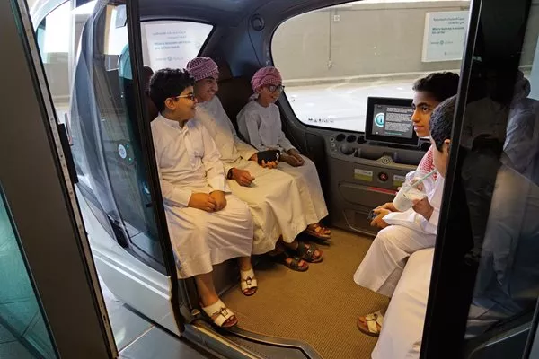 <p>Visiting students get ready for a ride on the Personal Rapid Transit (<span class="smallcaps">prt</span>), which still operates on the lower deck of the first sector of the city. Although city-wide <span class="smallcaps">prt</span> plans were suspended to control costs, light-rail and metro lines are under construction.</p>
