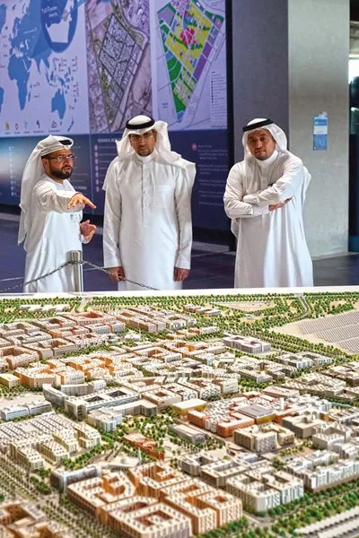 <p>Visitors to Masdar Institute view a model of the city as currently planned for 50,000 residents and 40,000 commuting workers.</p>
