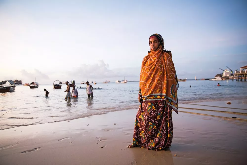 Rabia Omar, a visitor to Zanzibar from the mainland, wears a kanga she purchased in Dar es Salaam, Tanzania, where the demand for kanga is no less than in Zanzibar. The mainland style favors heavier cotton with darker, deeper colors than the Zanzibari style.

