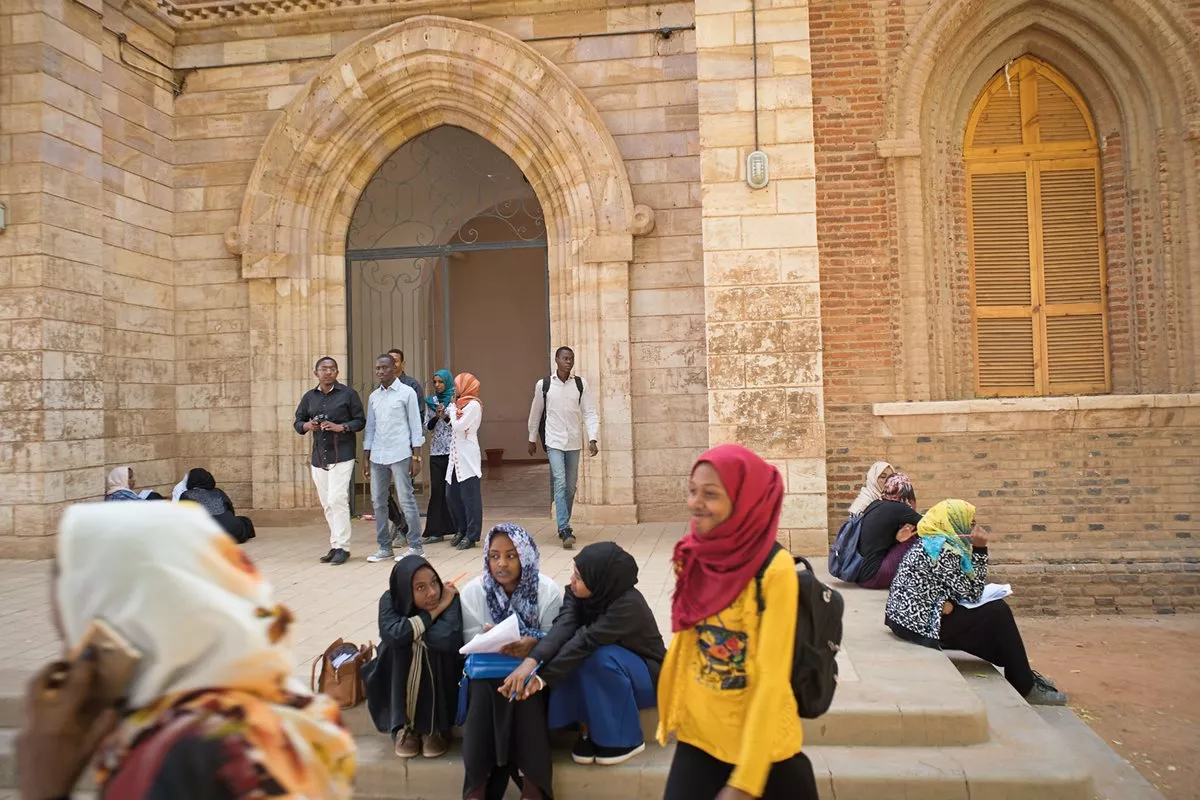 Students chat and check classwork on the steps of the main library at the University of Khartoum, founded in 1902 as Gordon Memorial College. The school is at the top of Sudan&rsquo;s educational system.