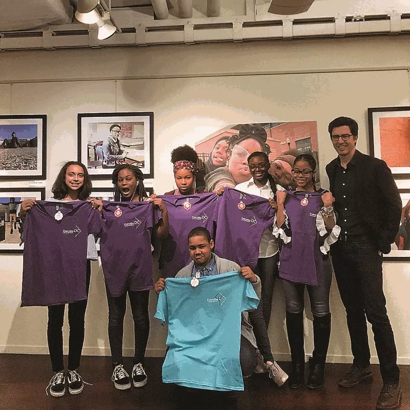<p>Jefferson Middle School Academy students pose with Everyday Projects cofounder Austin Merrill, at the opening of the exhibition &ldquo;Everyday DC&rdquo; at Pepco Edison Place Gallery in Washington, D.C. The students were among 150 who documented daily life in the District of Columbia in what is now a three-year-old annual educational and photographic event.</p>
