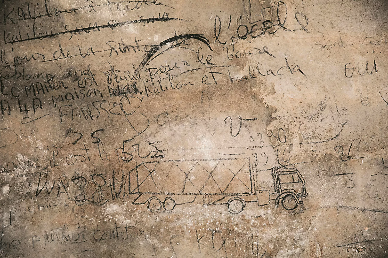 Other transport calculations appear on a wall in the groundnut section at Brikama market.