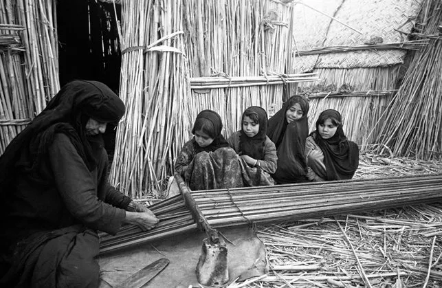 Lesson time for these girls meant watching their grandmother weave on a ground loom with a reed heddle, supported on stones. The girls would soon make their own attempts at weaving.