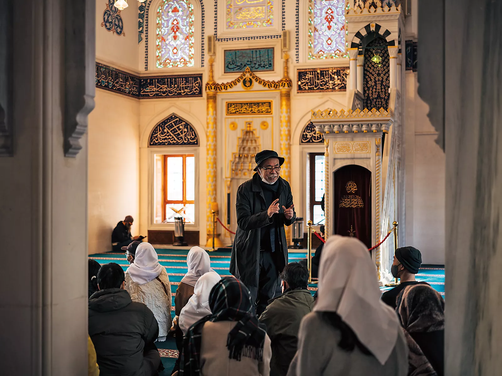 Shigeru Shimoyama, a public affairs officer at Tokyo Camii, explains the mosque’s history to a group of visitors in the main prayer hall. 
