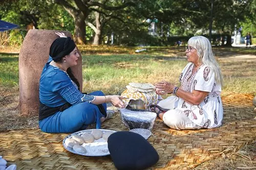 Faten Al Saedi, left, teaches Lynda Werner how to make bread at the event.