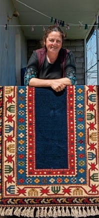 woman displaying a Borchalo rug