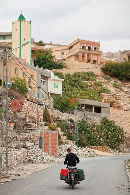 A man carries water on his motorbike from the town spring to vegetable and fig gardens in the village of Kesra.
