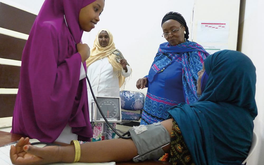 With Adan looking on together with outpatient department head Asha Farah, third-year nursing student Najah Ahmed Mohamed takes a patient’s blood pressure. To build the hospital that opened in 2002, Adan sold her home and donated her pension from 30 years of work with the World Health Organization.