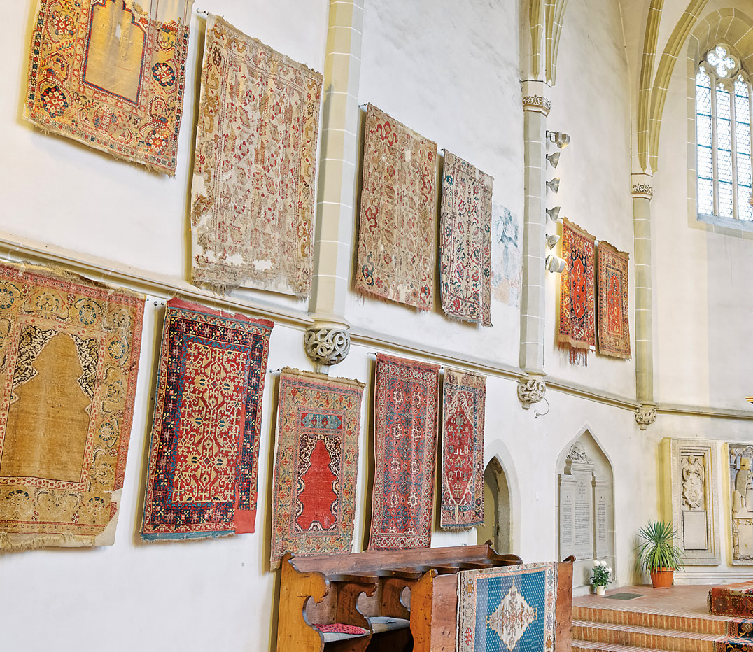 With the coming of Reformation aniconism—proscriptions against religious imagery—church frescoes were whitewashed or destroyed. The Anatolian rugs, with their soft colors and floral or complex geometric motifs became a prestigious decoration for churches. In St. Margaret’s Church in Mediaş, several fine types of Ottoman rugs survived: Holbeins, which are the earliest; Lottos; white-ground Selendis of three types—”bird,” “scorpion” and <i>çintamani</i>; and a variety of rugs called “Transylvanian” rugs.