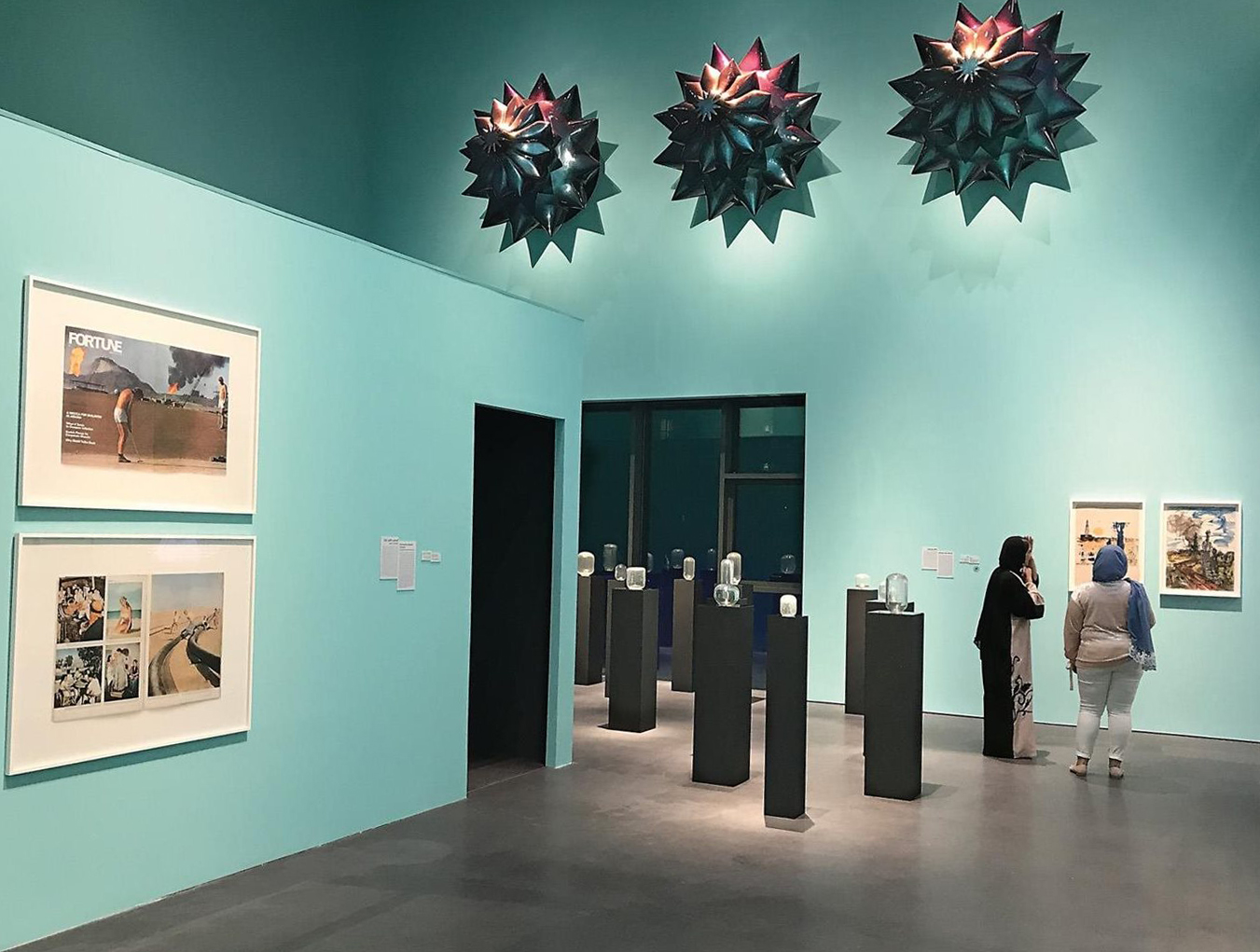This gallery view of &ldquo;Crude&rdquo; includes works by four of the show&rsquo;s 17 artists: Monira Al Qadiri, &ldquo;Flower Drill,&rdquo; 2016, fiberglass and automotive paint, top; Raja&rsquo;a Khalid, &ldquo;Fortune/Golf,&rdquo; 2014, archival inkjet prints, left; Michael John Whelan, &ldquo;Aqua Lung,&rdquo; 2018, blown glass objects made of sand obtained from the site of Jacques Cousteau&rsquo;s 1954 British Petroleum-sponsored maritime survey, center; paintings by Houshang Pezeshkhian, right.