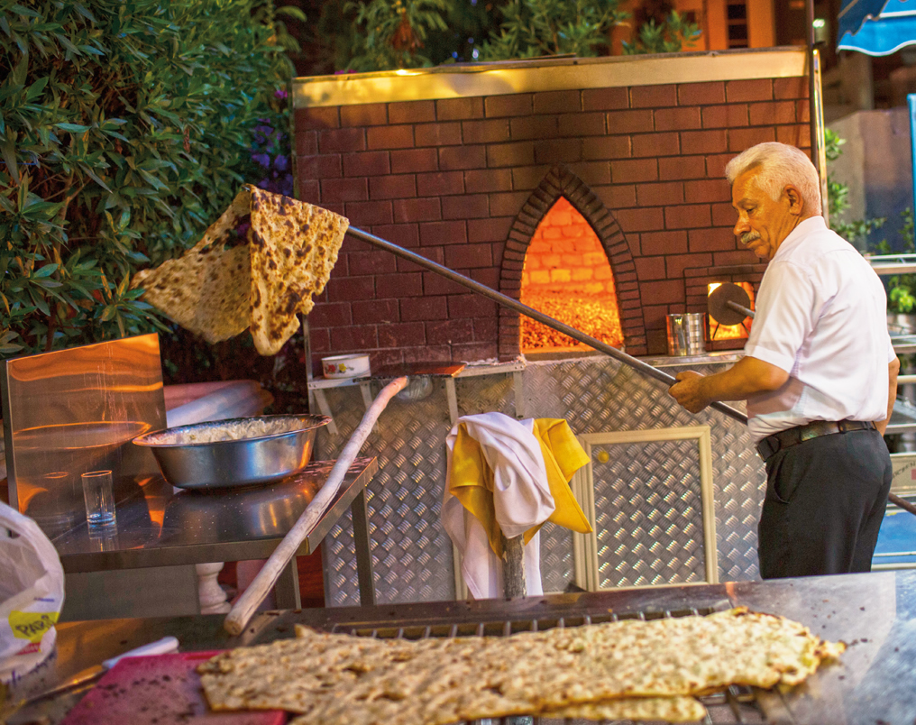 Hamid Aziz swings a flatbread out of the oven just as he has done for more than 35 years, both at home in Iran and, for the last decade, at Pars Iranian Bakery.