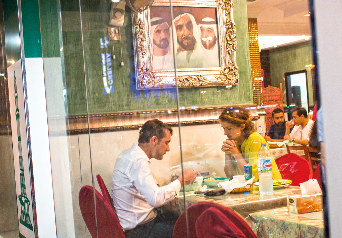 At Pars Iranian Bakery and Kitchen a pair of diners enjoy dinner under an Emirati official portrait.