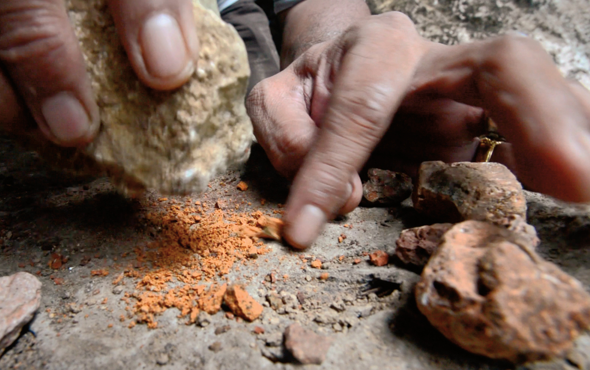 <p>Pulverizing ochre that remains common in the area, Ramli demonstrates the first step in making the pigment used for many of the drawings.</p>
