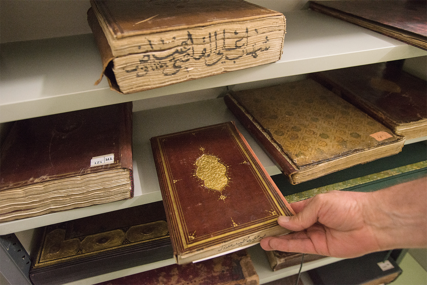<p><em>위:</em> 몇 세기 전으로 거슬러 올라가 만들어진 수많은 양각 무늬가 있는 가죽 커버로 아름답게 덮인 서적들이 Gazi Husrev-beg 도서관의 25,000권의 컬렉션 중에 있다. Gazi Husrev-beg가 보스니아(오늘날 보스니아와 헤르체고비나) 총독으로서 사라예보에 도착한 1521년에 가져온 책들이 그 중심에 있었다. <em>아래, 오른쪽:</em> 사라예보 동방연구소의 전 소장인 Lejla Gazič은 1992년 5월 16일 밤 세르비아 국가주의자들이 연구소를 폭발시킨 후 책들이 불타는 것을 무력하게 지켜보았다. 그녀는 아직도 도서관을 공격한 이유에 대해 이해하려고 애쓴다.</p>
