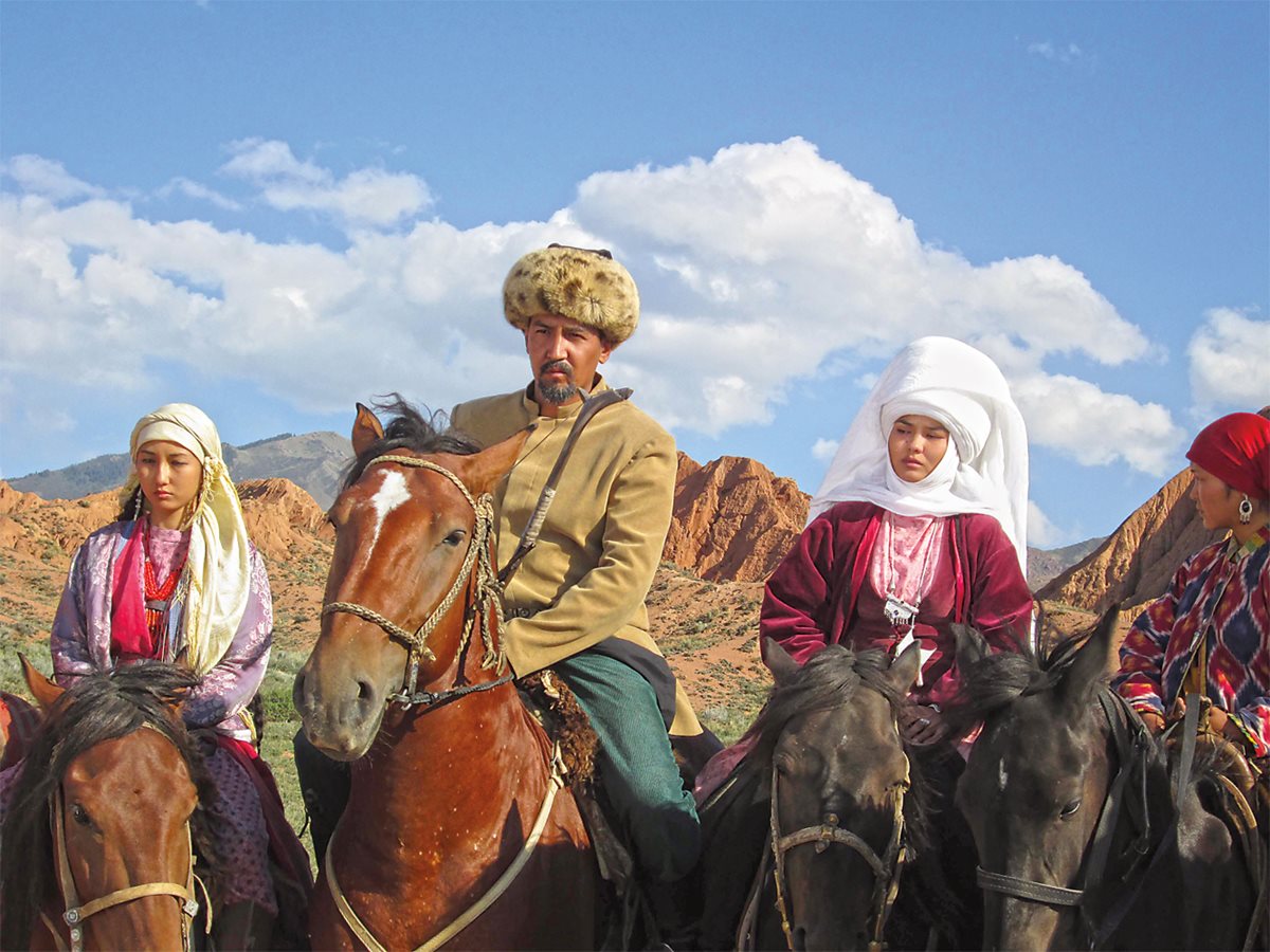 <p>Awaiting cues on location are co-stars Mirlan Abdylaev, center, who plays Kurmanjan’s younger brother, and Gulnur Asanova, right, who plays Asel, wife of Kurmanjan’s ill-fated son, Kamchybek. Asanova wears a traditional Kyrgyz headpiece called <em>elechek,</em> a rolled white cloth up to 30 meters long that could be used to wrap a woman’s body should she not survive a journey. </p>