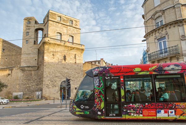 A tram decorated by fashion designer Christian Lacroix glides past the 12th-century Tour de la Babote, one of just two towers that remain from the 25-tower wall that once surrounded Montpellier.