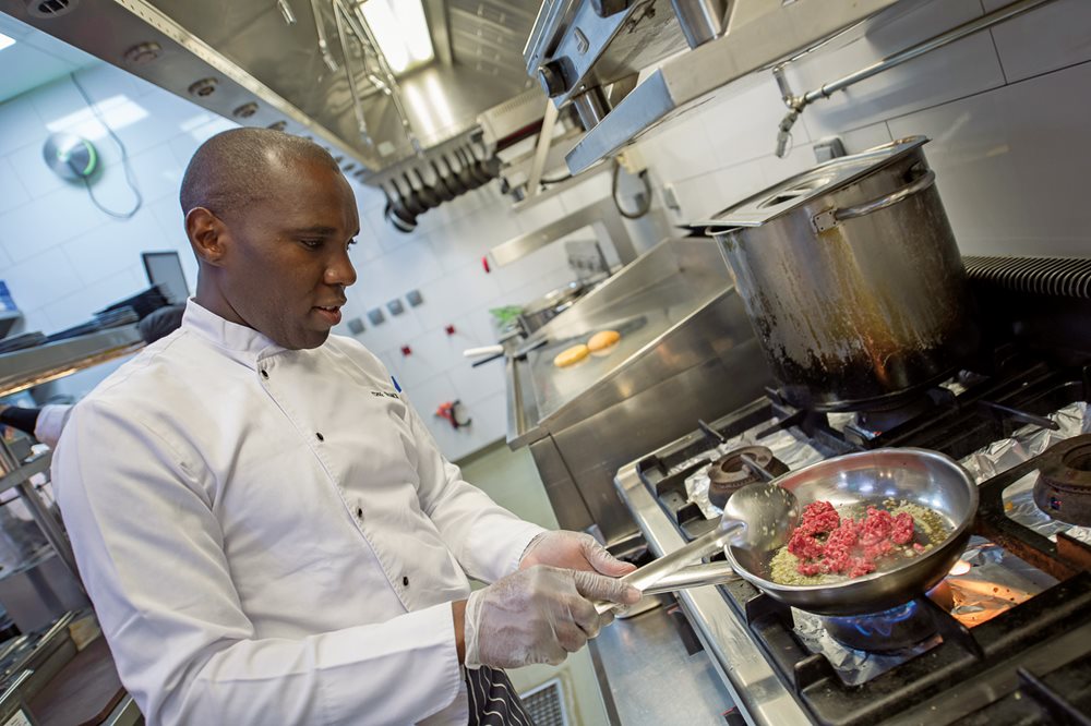Chef Francis Mungai Njogu prepares minced camel meat for a Camel Bolognese at Switch, whose menu, <i>below</i>, offers several camel dishes.