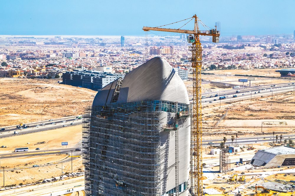 Scaffolding and a crane help workers attach the stainless steel cladding to the top of the Knowledge Tower in 2015. Ithra, Saudi Arabia