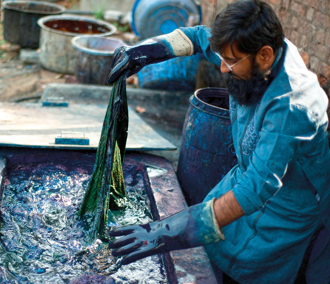 In Gujarat, India, a contemporary dye master works a textile in a vat of indigo. Over the centuries, indigo&rsquo;s unique colorfastness made it a favorite for heavy-use attire such as military uniforms, industrial work coveralls, and pants first made with American cowboys in mind&mdash;blue jeans.