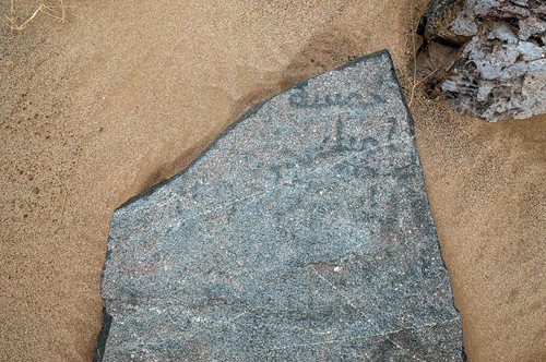 The flat basalt slab of milestone 28 is one of several with inscriptions in a style indicating they were written before the middle of the ninth century CE. Alkadi believes the Arabic words khamsa mil (five mil) refer to the distance to the nearest postal station, a string of which had been established by that time along the route at intervals of 12 mil called barid. This was a distance that allowed a camel-mounted rider to deliver and return to station in the same day.