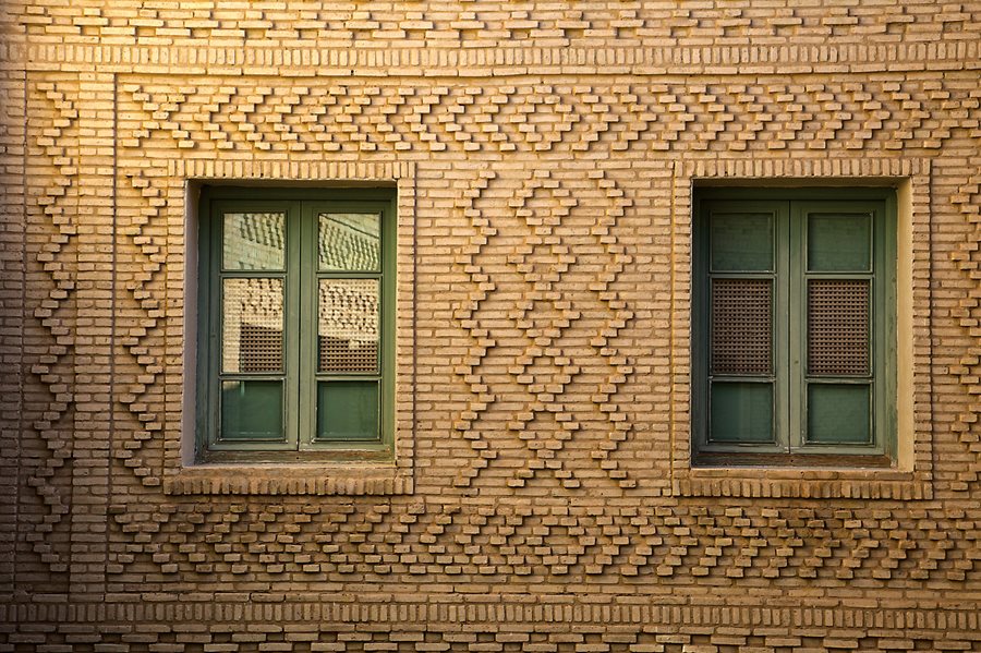 A hotel window is framed in brick designs. 