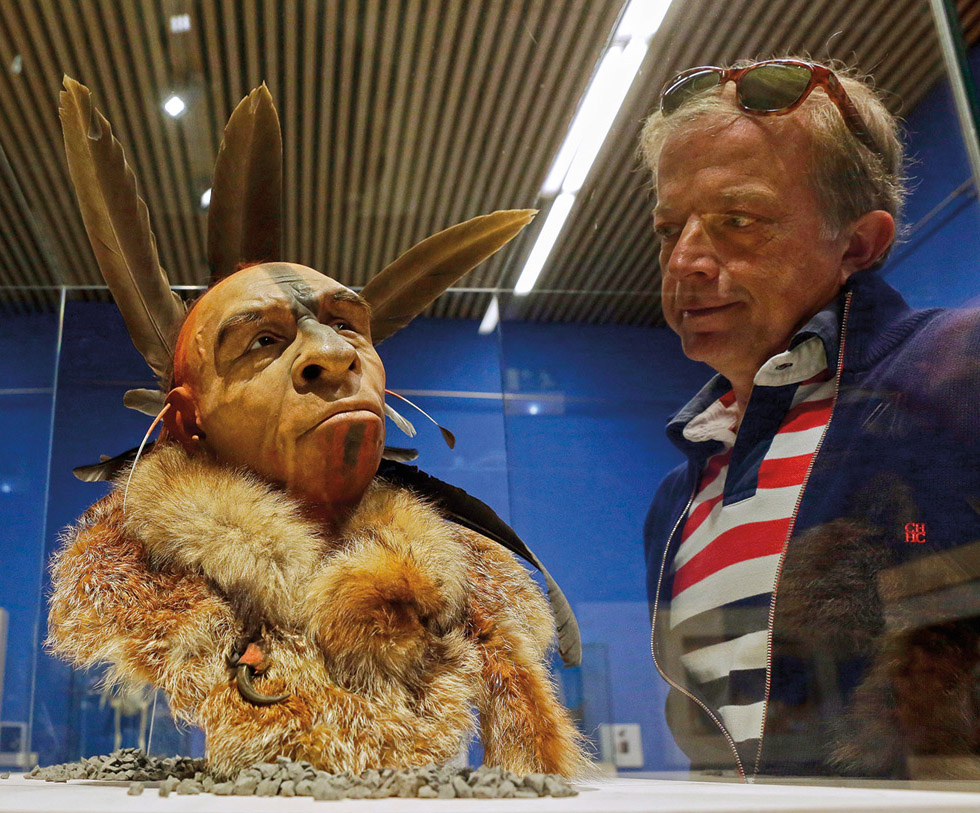 A visitor to the exhibition “Cambio de Imagen” (Change of Image) at the Museum of Human Evolution in Burgos, Spain, looks on a model of the face of a Neanderthal man.