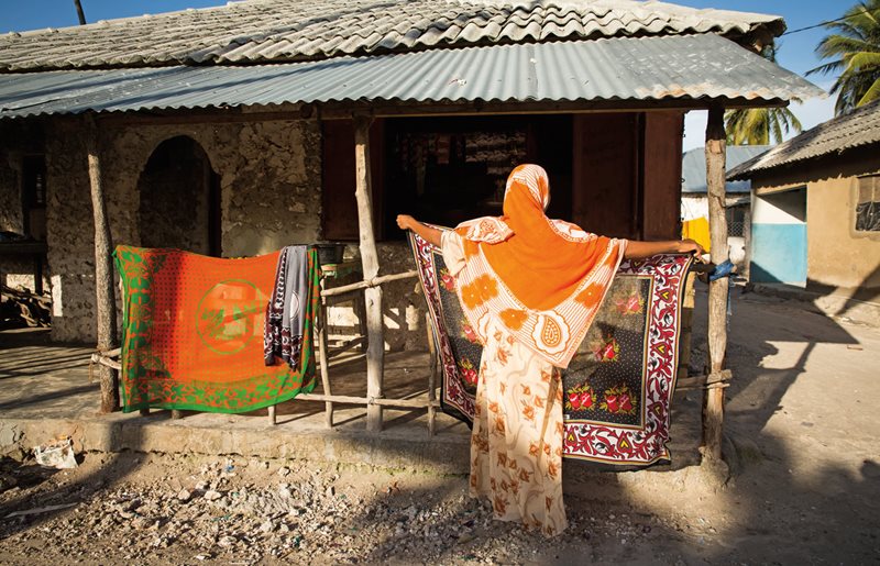 A villager in Bwejuu hangs out a kanga to dry in the morning sun.