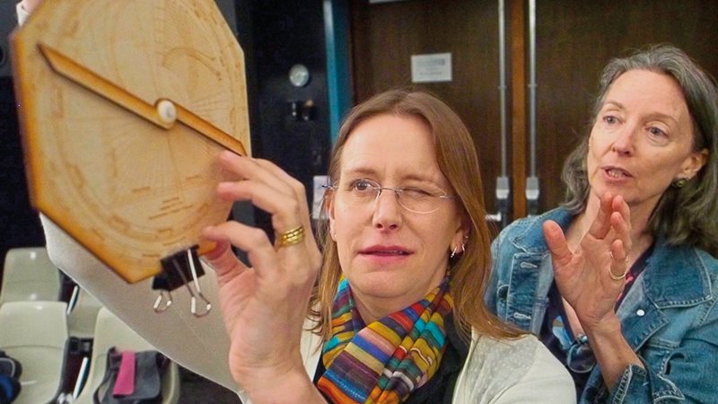 The author guides her stepdaughter, Isa, as she sights along the astrolabe&rsquo;s alidade to calculate the height of a balcony in an auditorium at Central Connecticut State University.