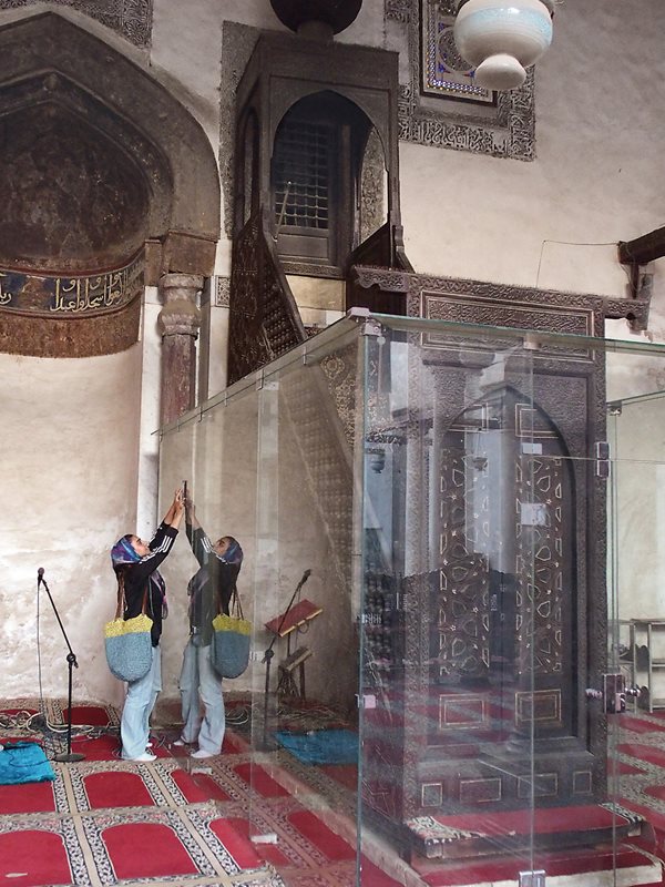 The minbar of the Mosque of al-Salih Tala’i, right, recently had four pieces stolen from its right side, and to deter further theft, it is one of several minbars EHRF has put behind glass.