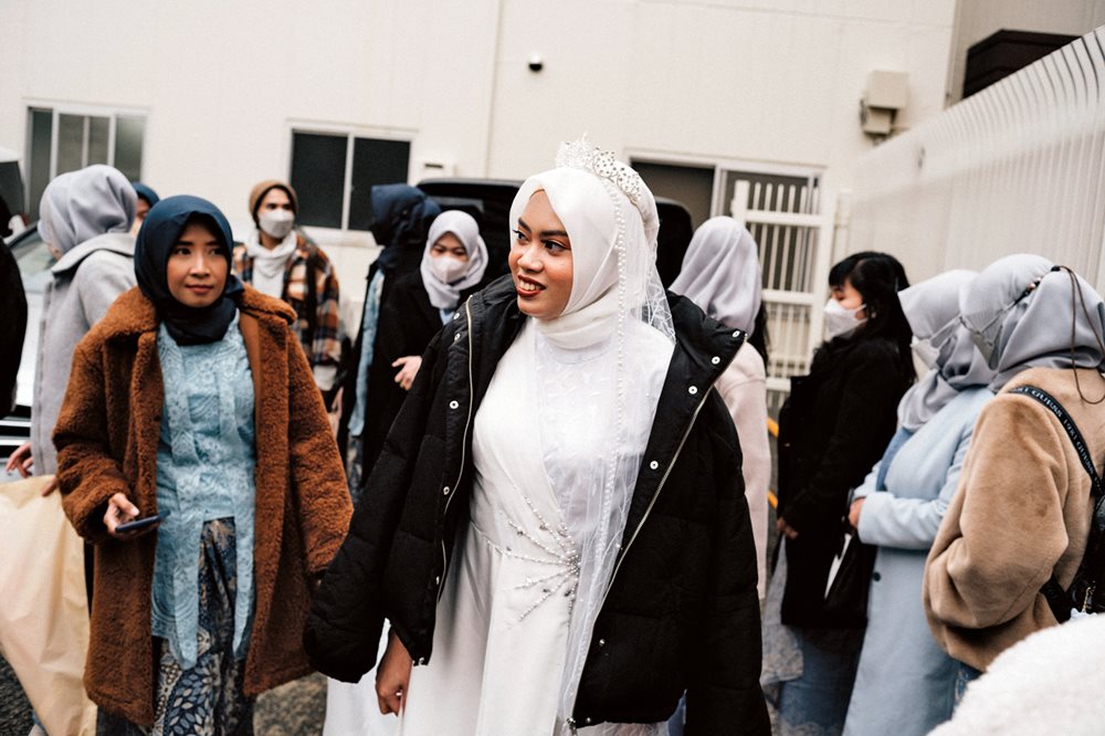 Bride Dita arrives at the mosque in Kobe for her wedding ceremony, surrounded by family and friends.