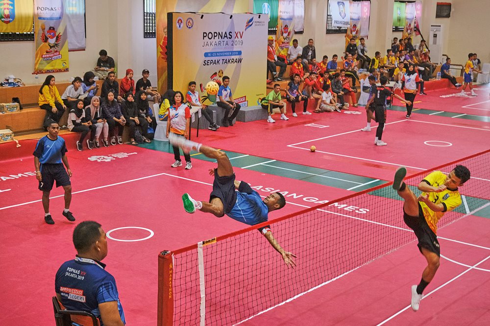 A sepak takraw striker from Papua Province kicks the ball as a Riau Province defender rises to block it during popnas XV, a national student event held every four years in November in Jakarta, Indonesia’s capital.