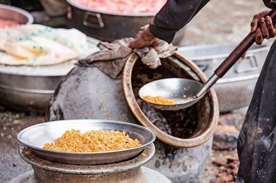 In Islamabad, Pakistan, a street vendor ladels freshly steamed biryani from a deep, wide pot called a dum.
