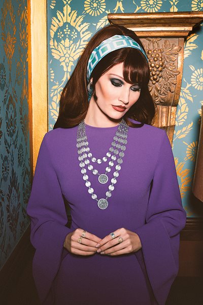 A model wears the Wadih El Safi Necklace with the lyrics written by Hussein El Sayed inscribed “Her eyes captured my heart, my mind left my body and I fell in love, I lost my mind.” Also worn are the Nizar Qabbani Ring, Diamond Crescent Ring, The Warda Ring, Sayed Darwish Ring, Laila Mourad Ring and Blessing Hoop Earrings.