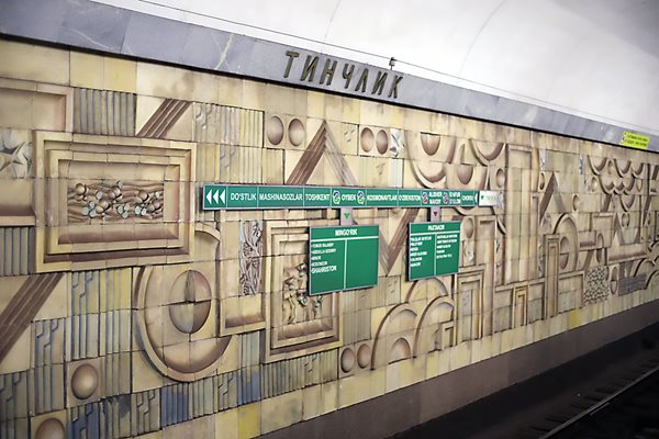 This mural at Tinchlik (Peace) is one of two that stretch the length of the rails on each side of the platform. Its simple, bold geometrical elements and warm, earthy hues evoke dynamic, yet harmonious relations among nations.