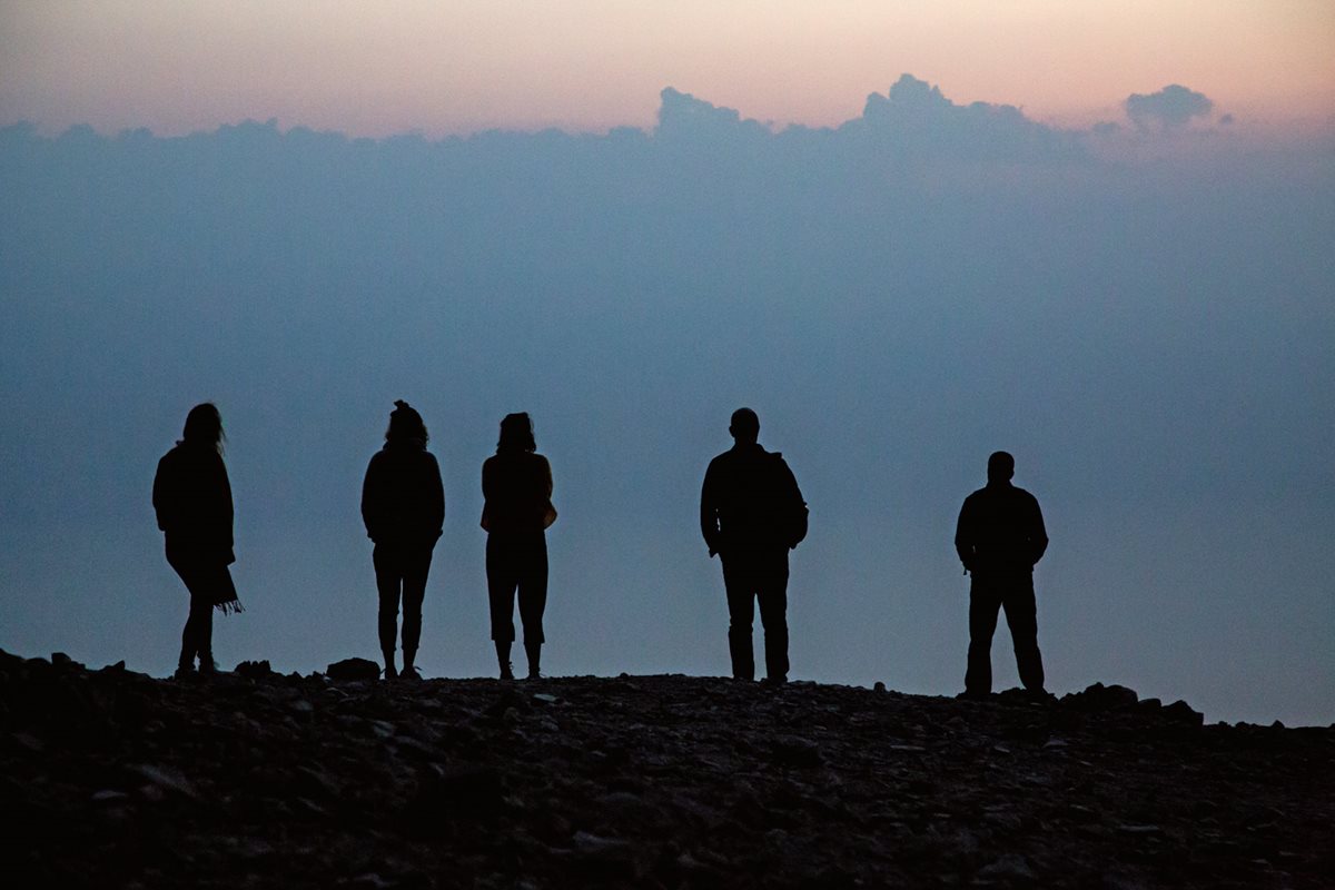 From cliffs above the Dead Sea, hikers look out over Jordan at sunrise.&nbsp;